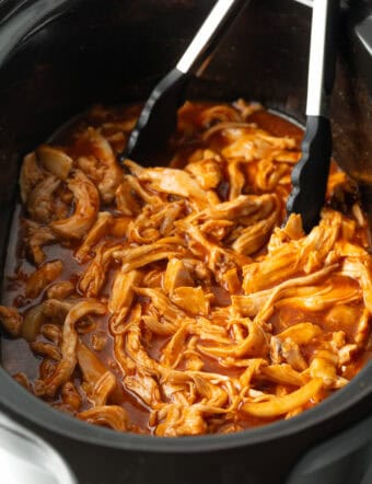 Barbecue Chicken in the Crock Pot with tongs