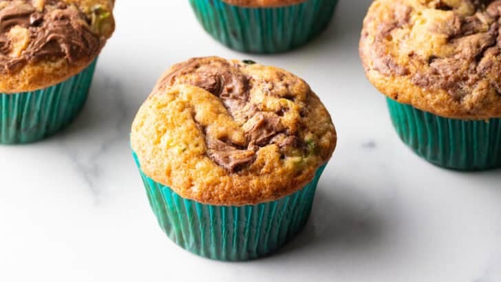 Soft zucchini muffin recipe with swirls of Nutella on top.
