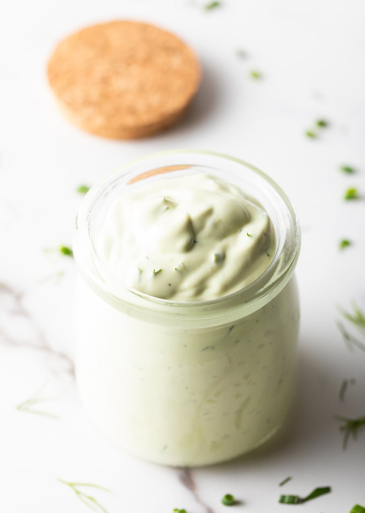 Glass jar of green creamy dressing.