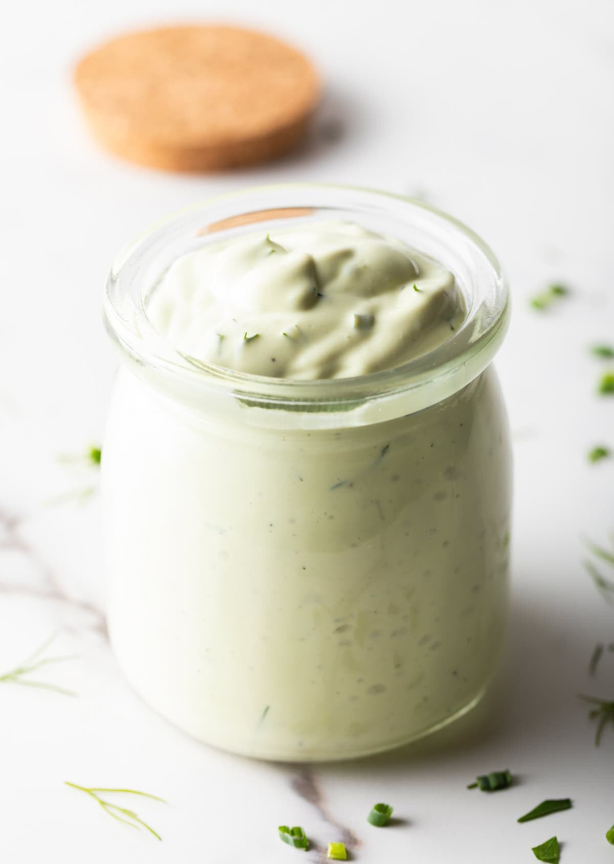 A glass jar filled with copycat Chick Fil A avocado lime ranch dressing.