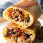 Two halves of a beef and cheese burrito stacked on top of each other.
