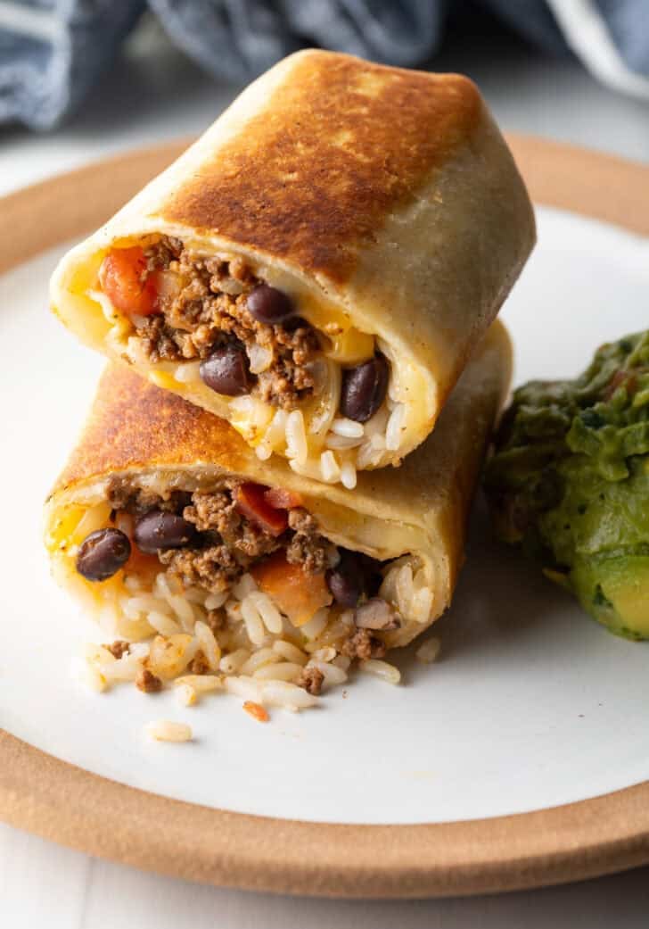 Two halves of a beef and cheese burrito stacked on top of each other.