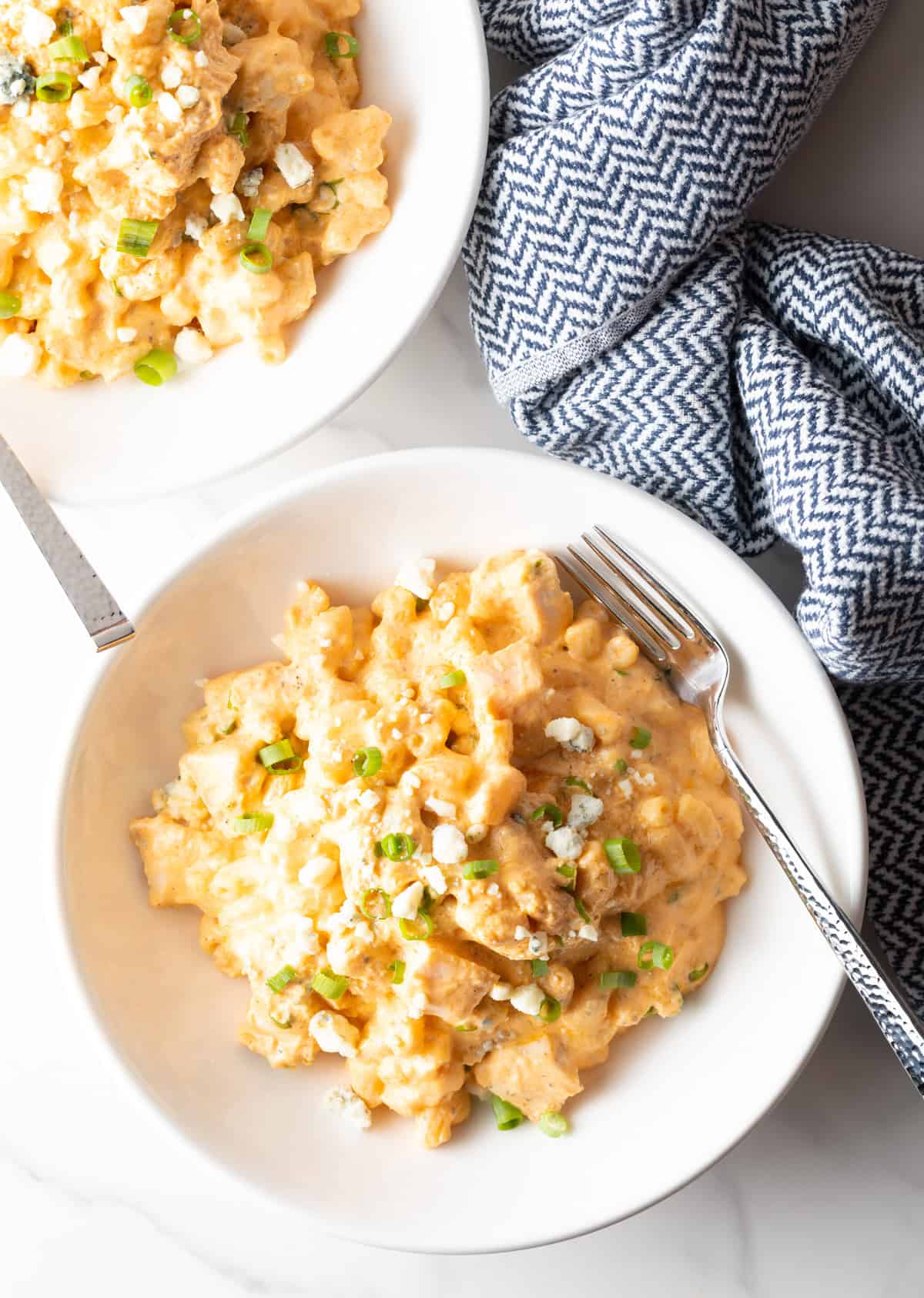 Top down view of white bowl of creamy cheesy buffalo chicken mac n cheese.