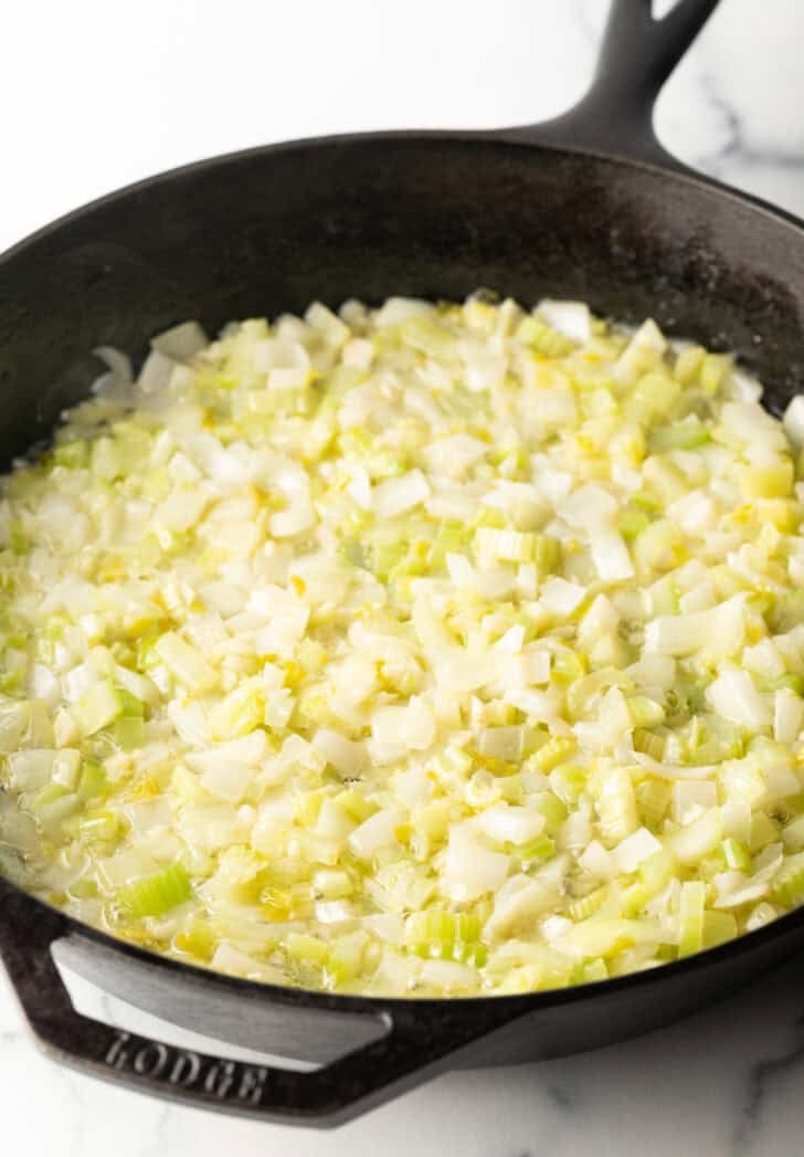 Cooking celery and onion in a cast iron skillet.