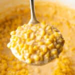 Ladleful of cream corn held to camera.