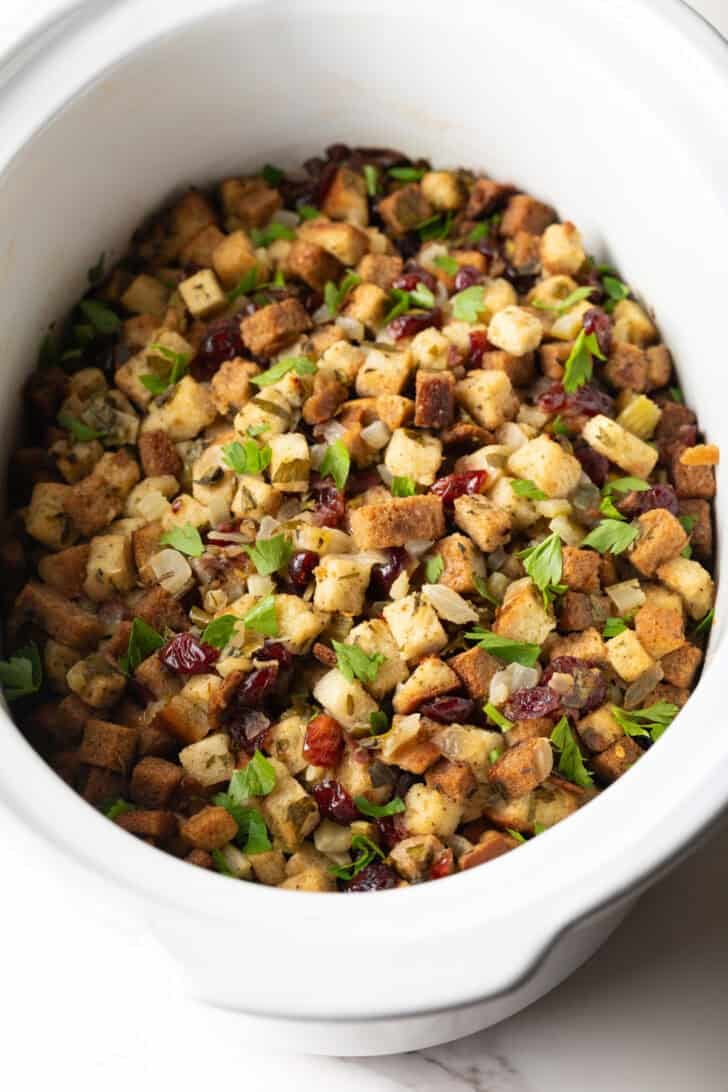 Overhead shot of crock pot stuffing recipe in a white crock pot.