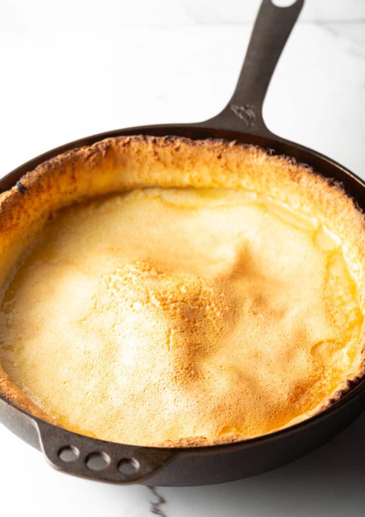 Baked Dutch baby in a cast iron skillet.