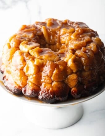Monkey bread baked in a bundt pan, plated on a white cake stand.