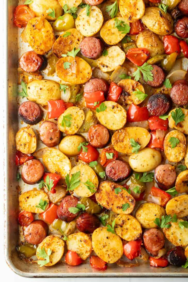 Overhead view of sheet pan kielbasa and potatoes recipe with parsley on top.