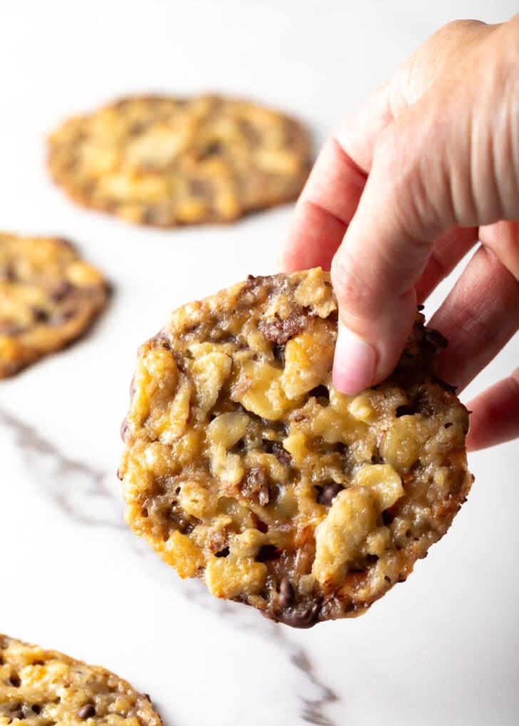 A hand holding a single Florentine cookie close to the camera.