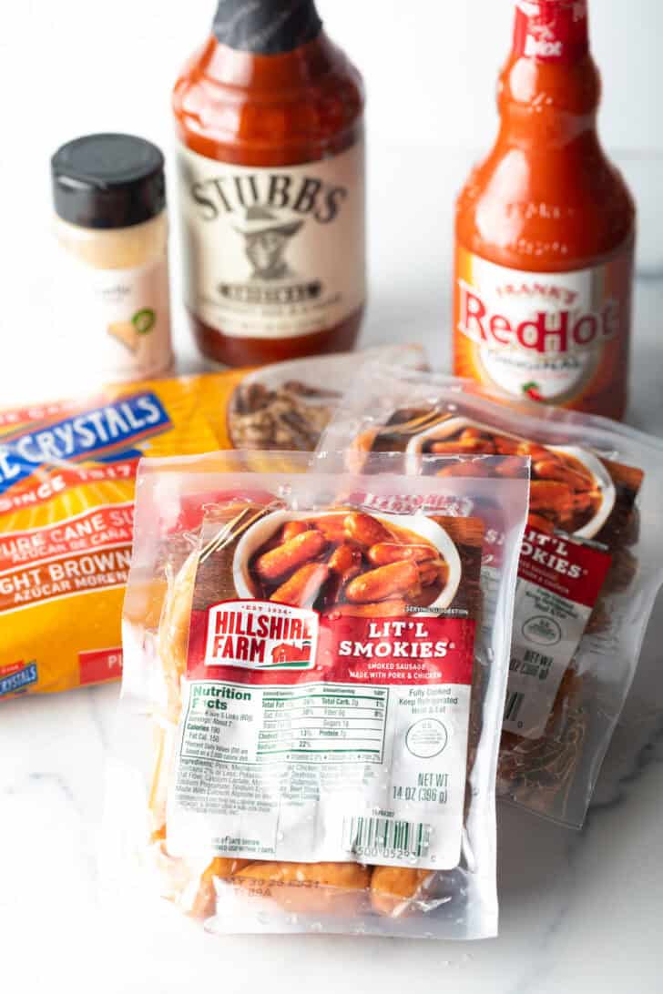 Recipe ingredients: A bottle of Frank's RedHot, Stubb's bbq sauce, seasoning, two packs of little smokies, and a bag of brown sugar.