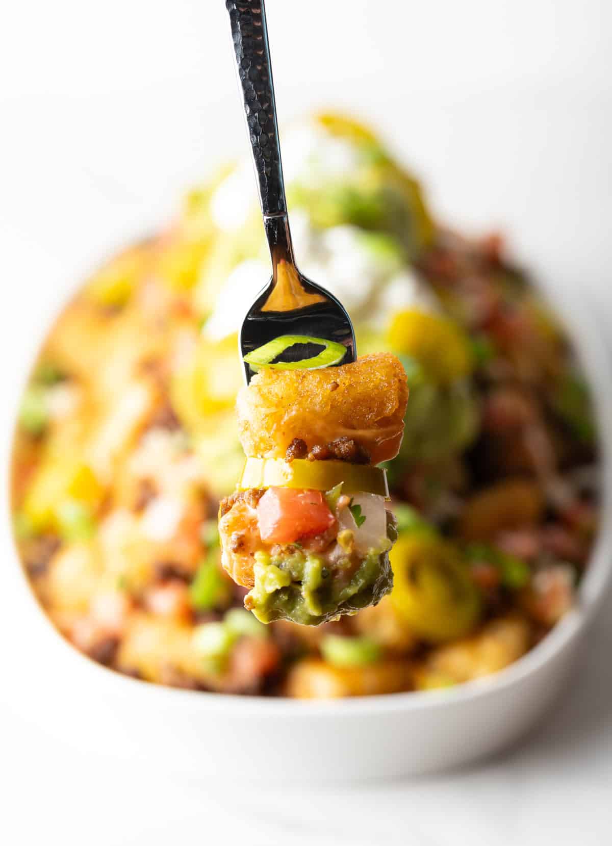 Forkful of totchos held to camera.