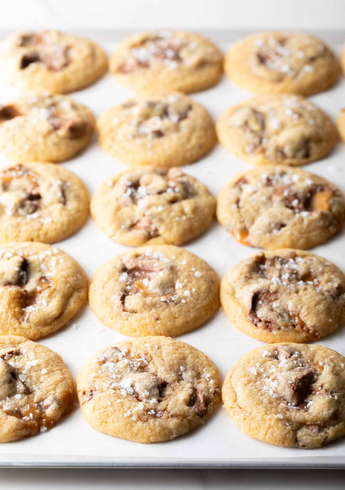 Freshly baked Milky Way cookies on a parchment covered cookie tray.