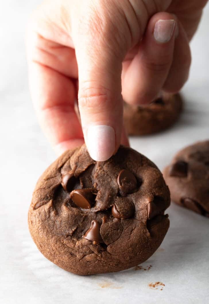 Hand holding a nutella and chocolate chip cookie to camera.