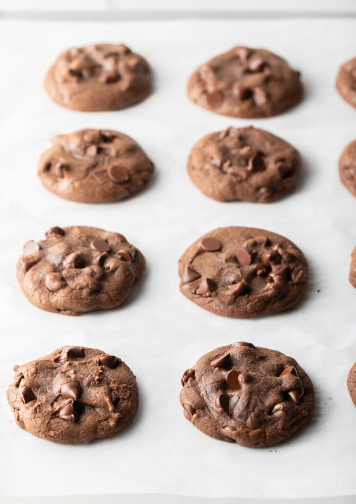 4 baked chocolate hazelnut cookies on a baking sheet.