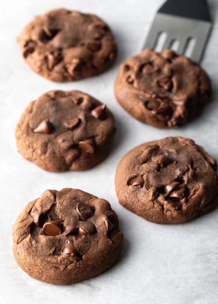 5 baked nutella cookies with chocolate chips on a white background.