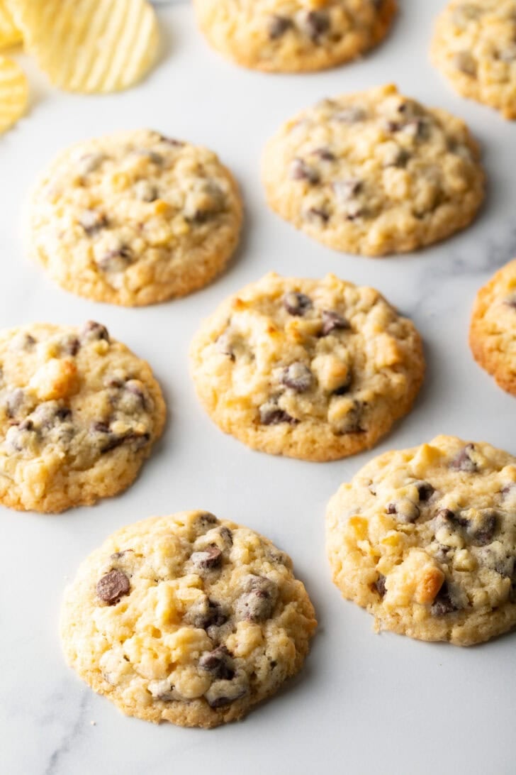 Baked potato chip cookies on white surface.
