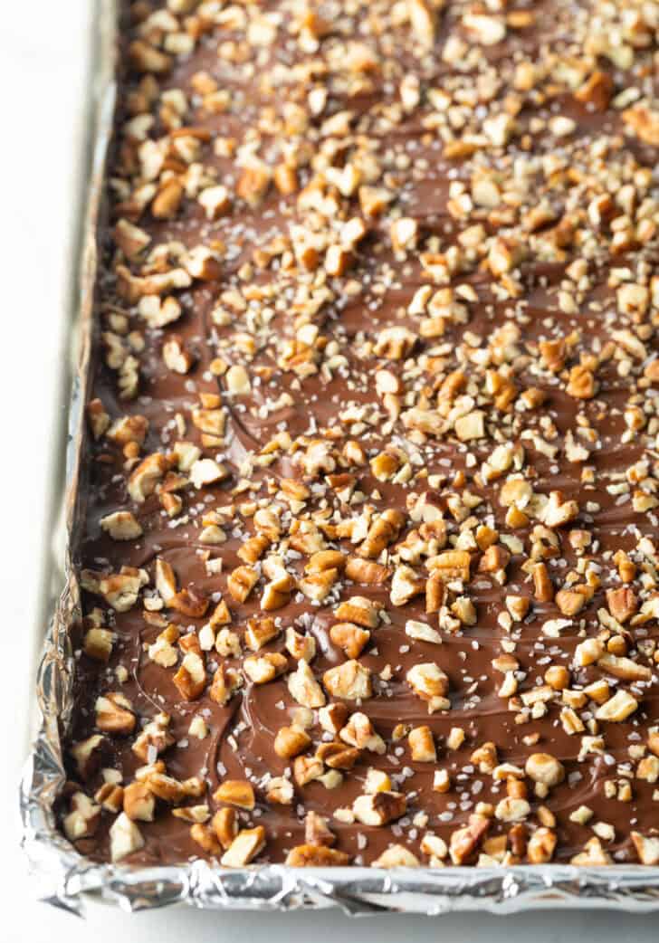 Rimmed baking sheet with chocolate and broken pieces of toffee.