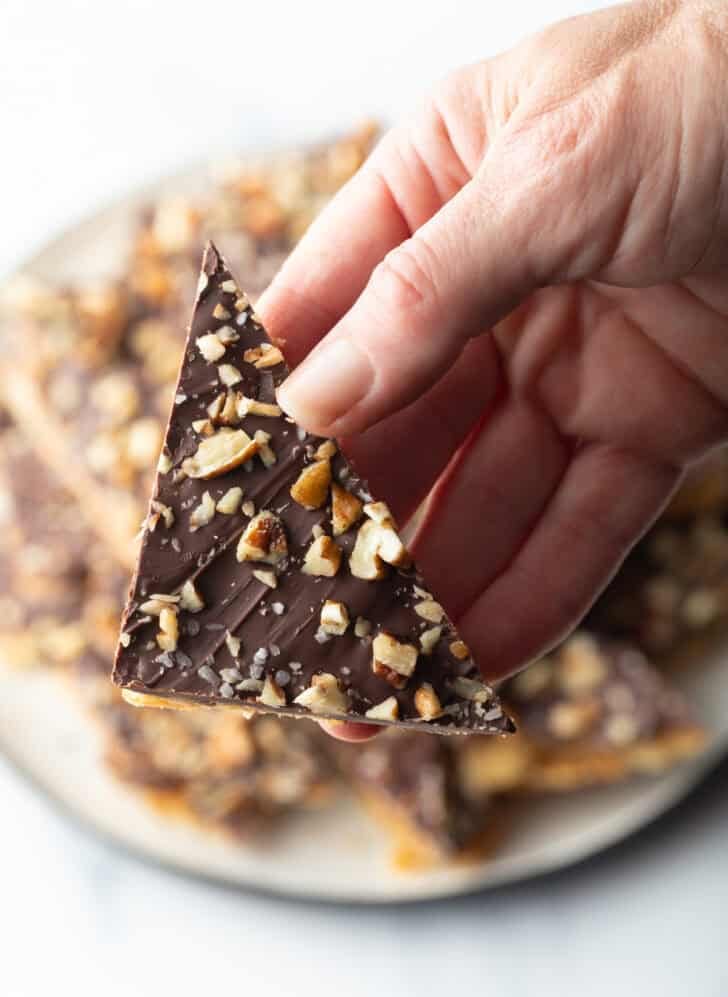 Hand holding a piece of saltine toffee aka Christmas crack.