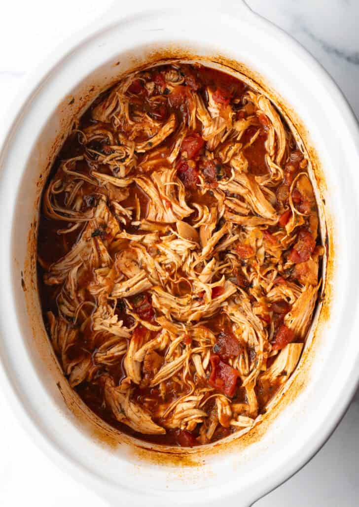 Top down view shredded Mexican chicken in a crockpot.