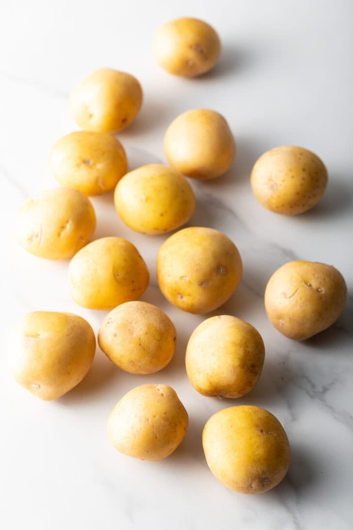 A dozen small yellow raw. potatoes
