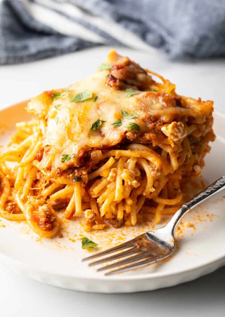 White plate with a serving of spaghetti bake and fork.