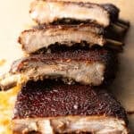 St. Louis style ribs stacked on top of each other on cutting board.