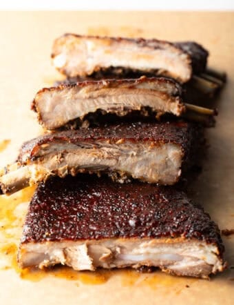 St. Louis style ribs stacked on top of each other on cutting board.