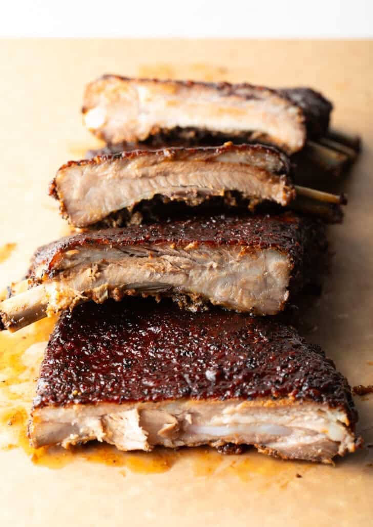 St. Louis style ribs sliced and stacked on top of each other on a cutting board.