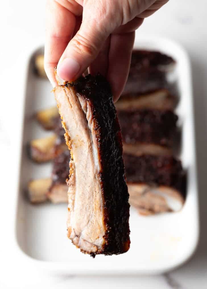 Shot of a single St Louis rib being held up to the camera.