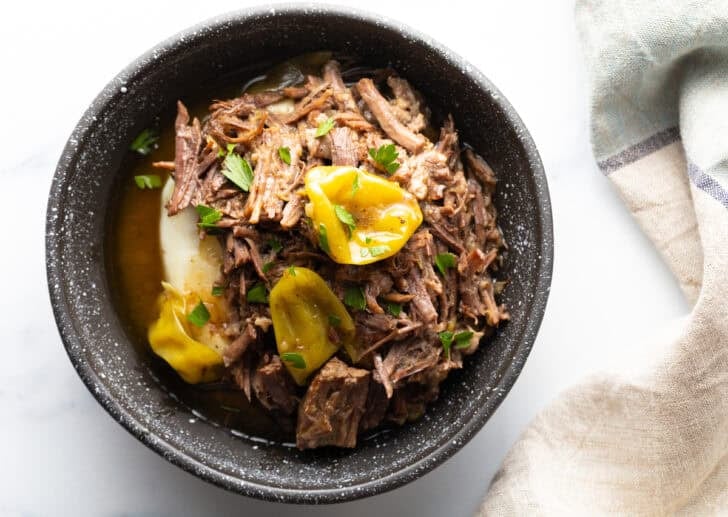 Mississippi Pot Roast recipe in dark bowl with mashed potatoes.