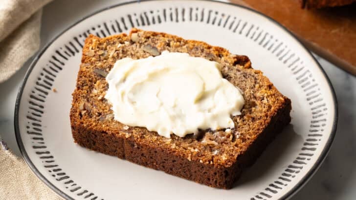 Moist banana bread recipe with 2 bananas on plate, with lots of butter