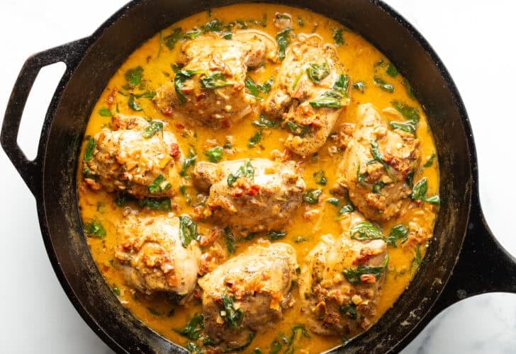 Overhead shot of Creamy Tuscan chicken thighs in a skillet.