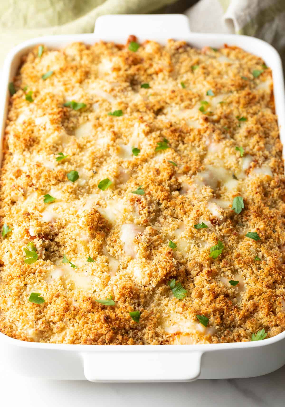 Baked parmesan chicken casserole in a white baking dish.
