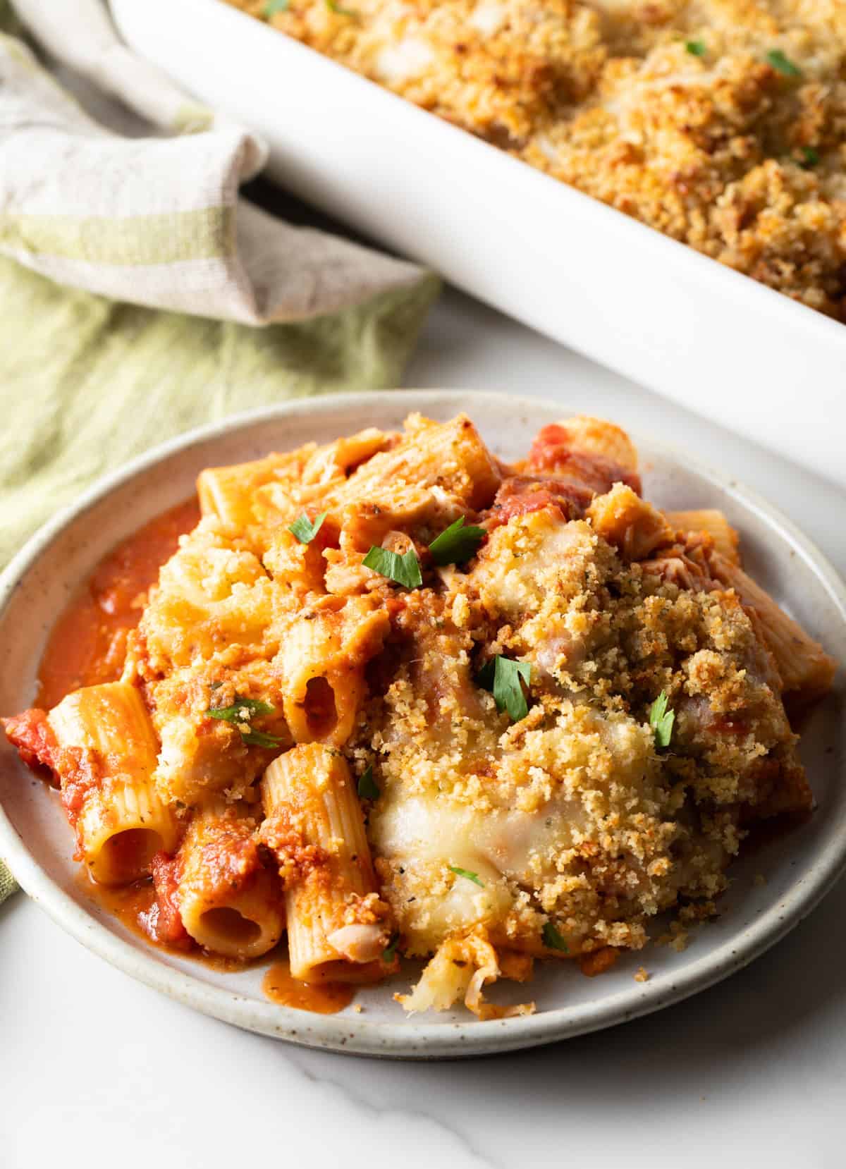 A helping of chicken parmesan casserole on a white plate.