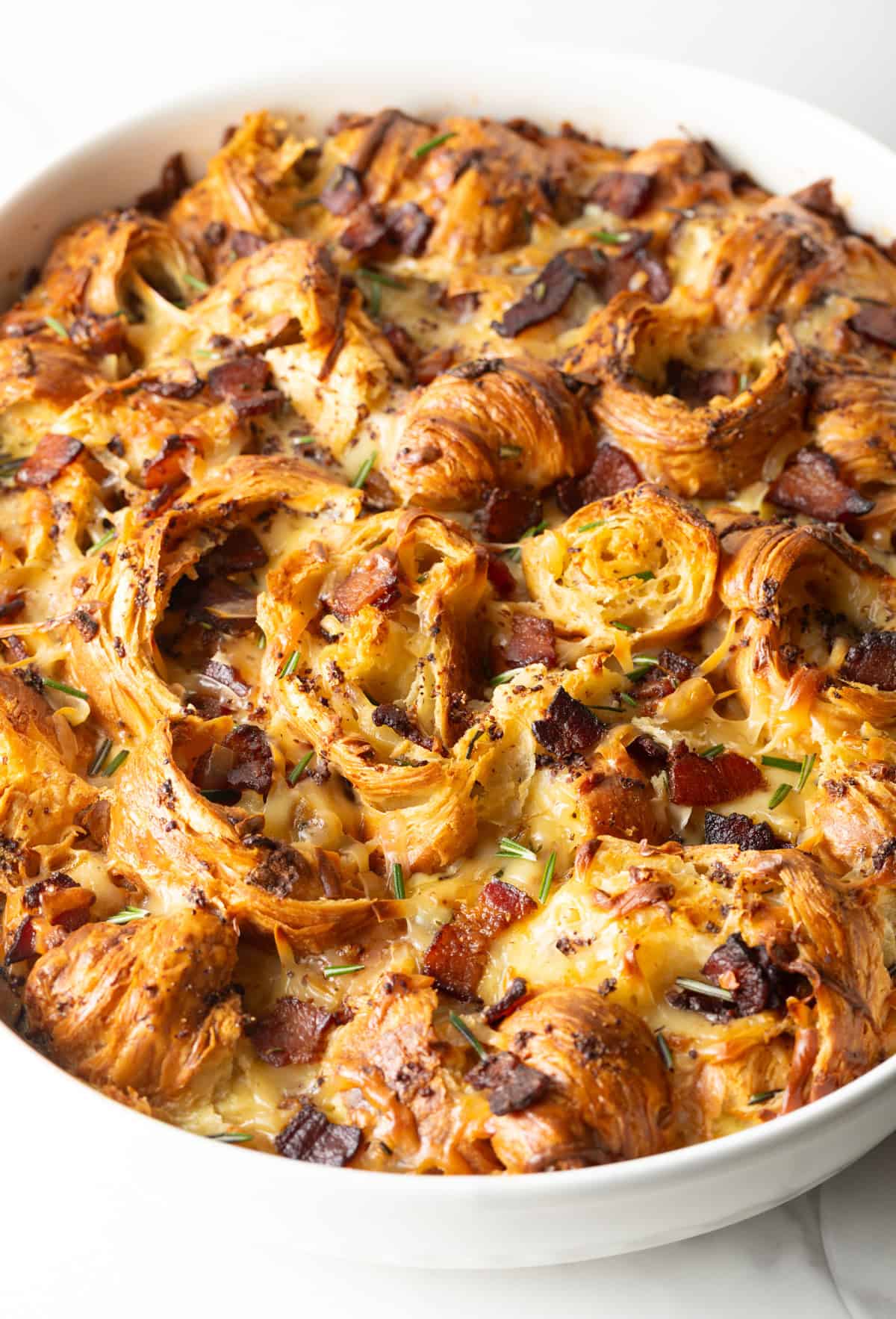 Overhead shot of croissant casserole recipe in a white baking dish, fresh from the oven.