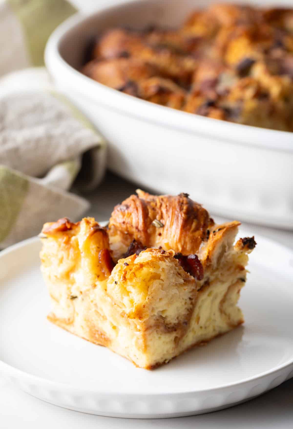 A slice of croissant breakfast casserole sitting on a white plate.