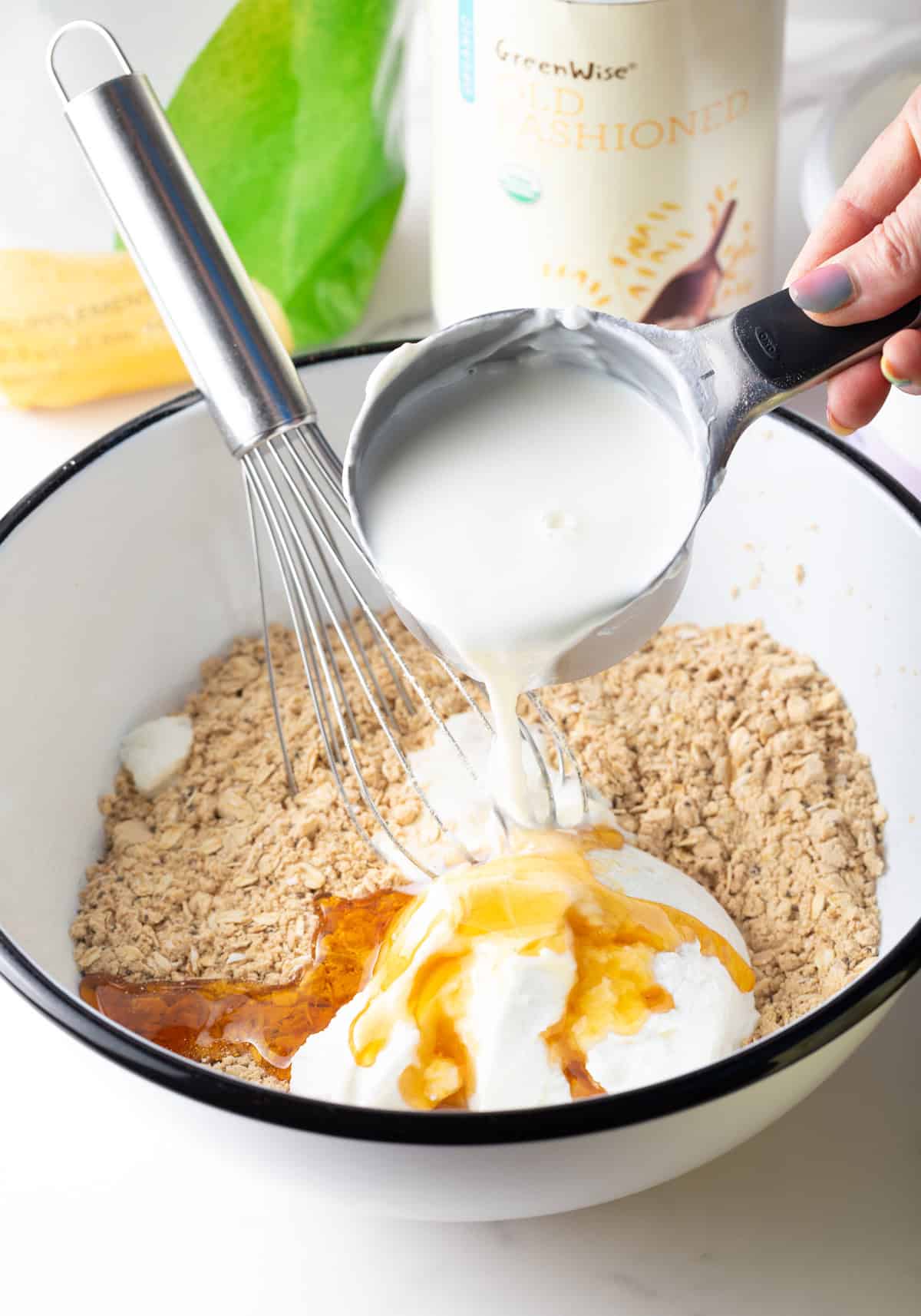 Milk being poured over the ingredients for high protein overnight oats recipe.