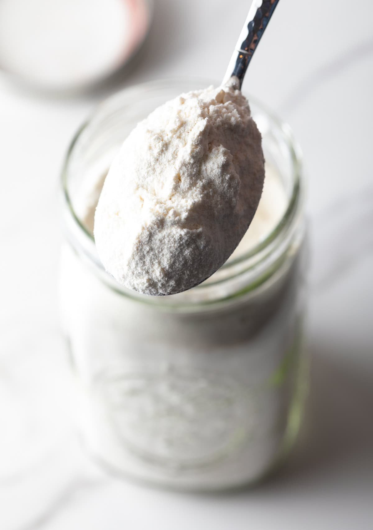 Close view a spoonful of homemade pancake mix held to camera.