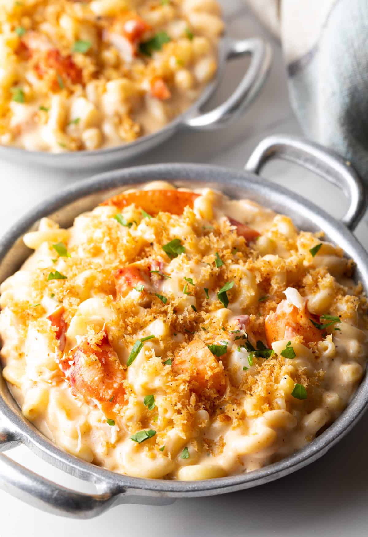 A metal bowl filled with creamy lobster mac and cheese.
