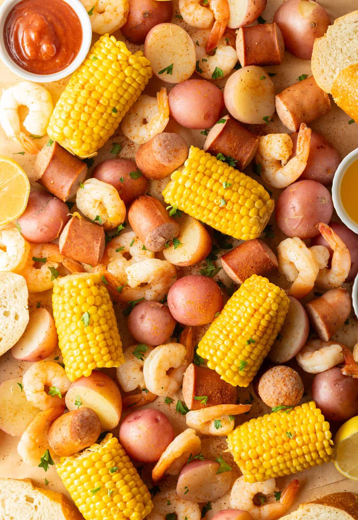 Overhead shot of shrimp, sausage, corn, and potatoes seasoned with Old Bay seasoning for low country boil.