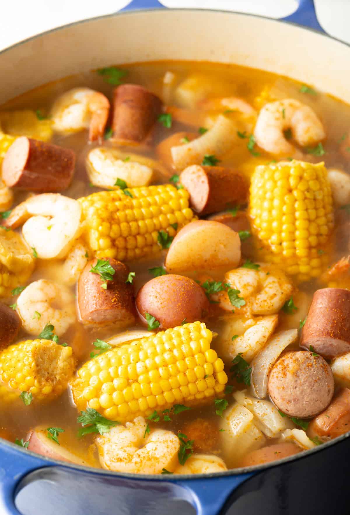 A pot filled with shrimp, potatoes, corn, sausage, and Old Bay seasoning for low country boil recipe.