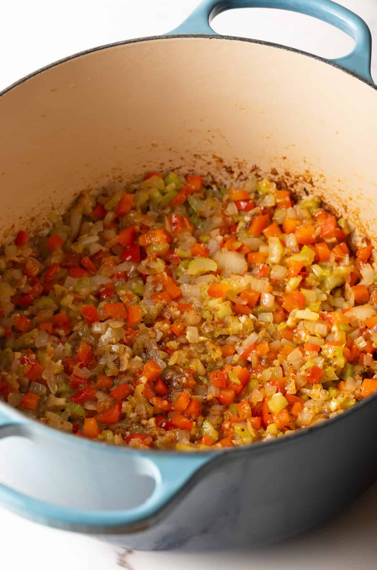 Vegetables being sautéed in a pot for the Cajun macaroni and cheese recipe.