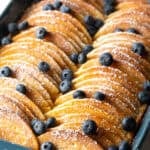Pancakes lined up in a blue casserole dish for a make-ahead pancake breakfast casserole.