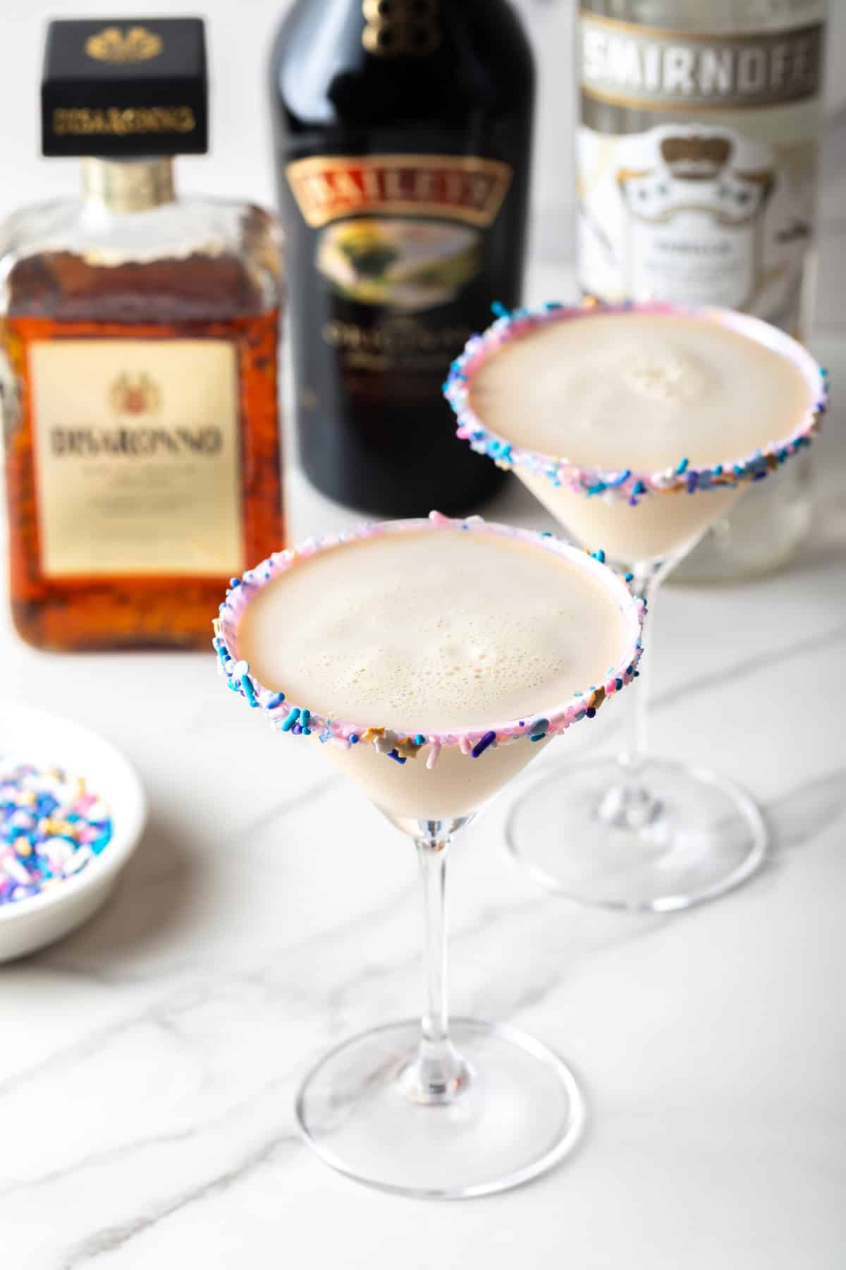 Two sugar cookie martinis lined with festive sprinkles.
