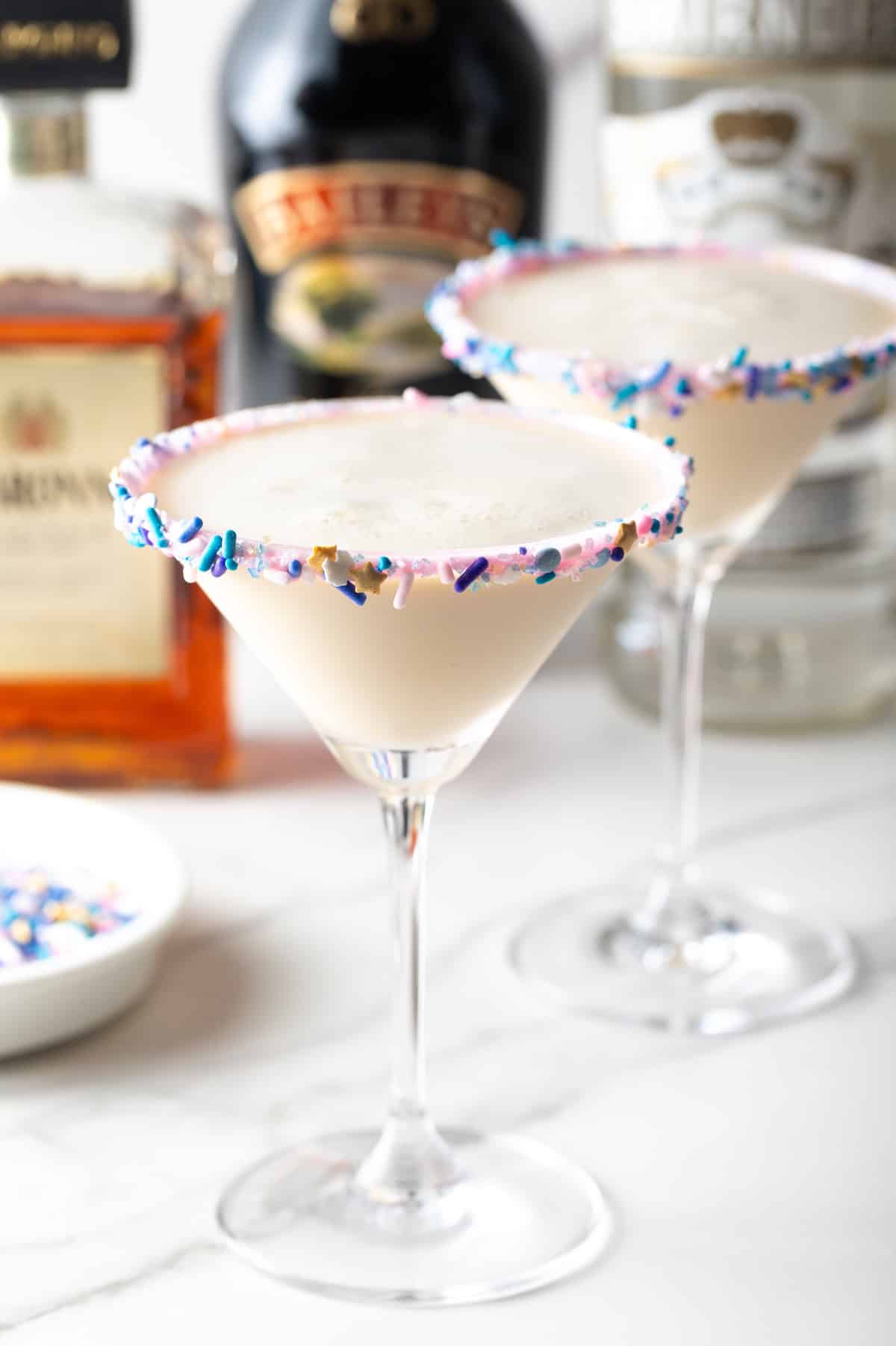 Sugar cookie martini cocktail with rainbow sprinkles on rim, festive brunch drink, dessert-inspired beverage, sweet party cocktail.