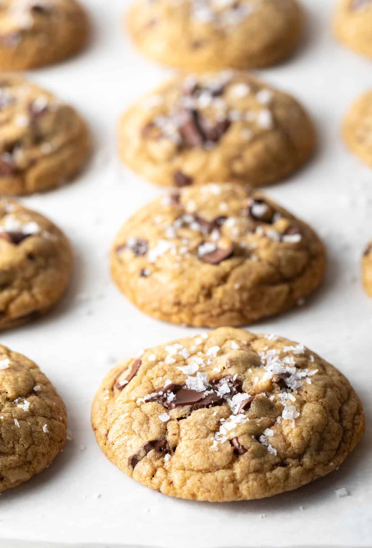 8 chocolate chip cookies made with brown sugar on a baking sheet.