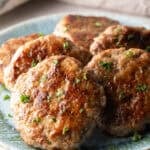 Slices of an easy homemade breakfast sausage recipe lined up in a circle on a blue plate.