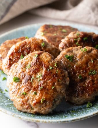 Slices of an easy homemade breakfast sausage recipe lined up in a circle on a blue plate.