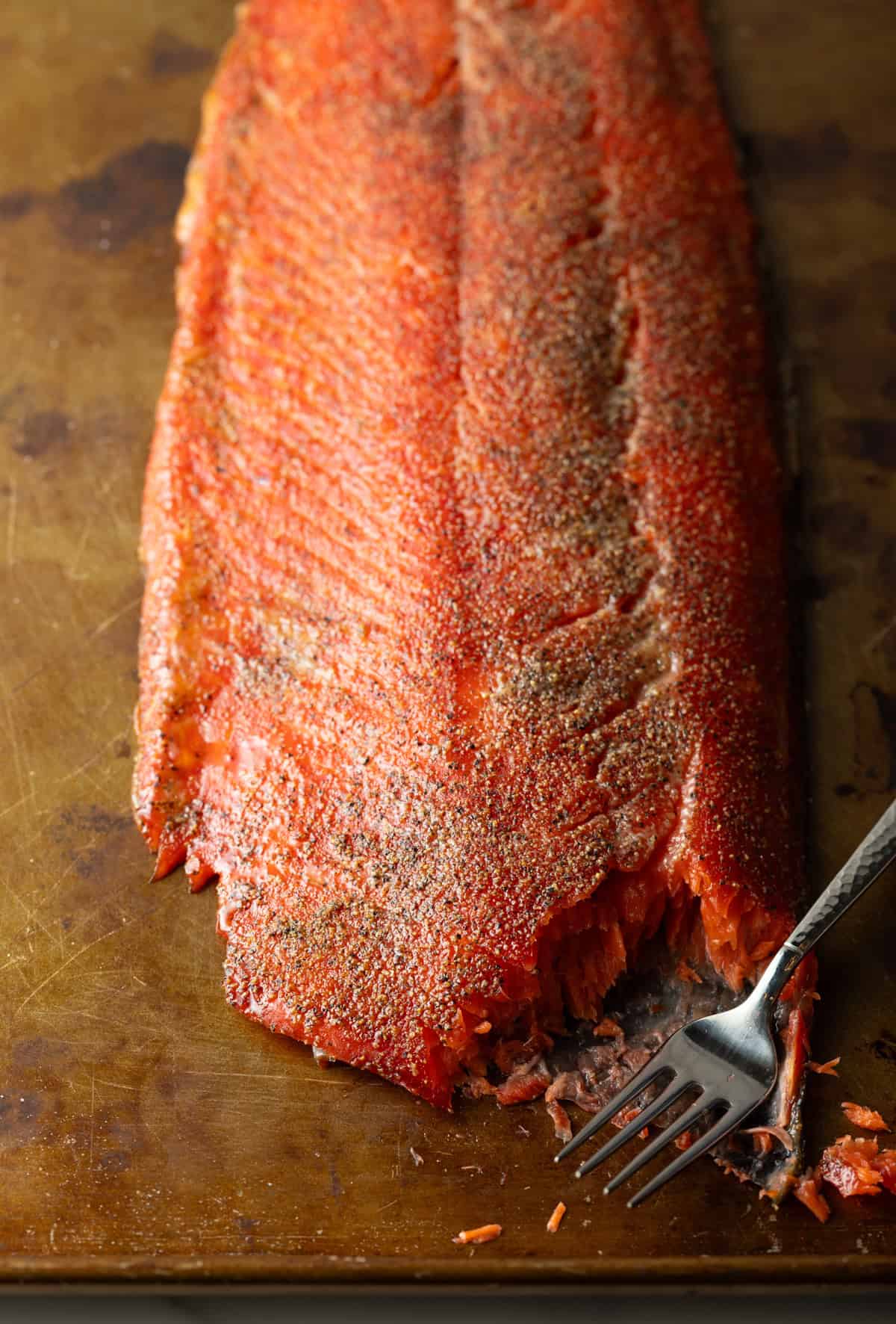 A a whole cold smoked salmon recipe with a fork that is cutting a piece off.